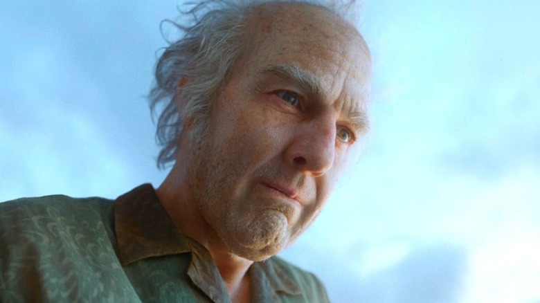 Tom Cruise as Digger Rockwell looking over a railing into the ocean in Digger