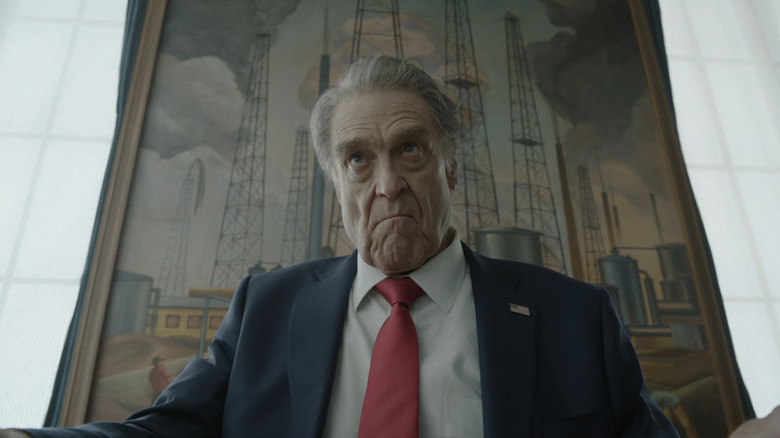 John Goodman as President Compson sitting at his desk in Digger