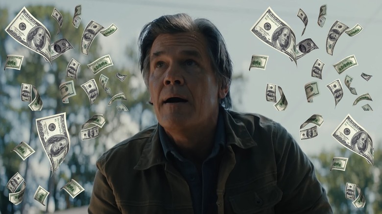 Josh Brolin as Archer watching in horror surrounded by money in Weapons