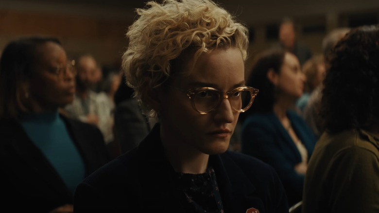 Julia Garner as Justine sitting at the meeting at the school in Weapons