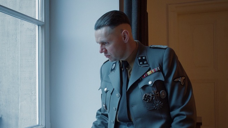 Rudolf Höss looking out of a winow, bored, in The Zone of Interest