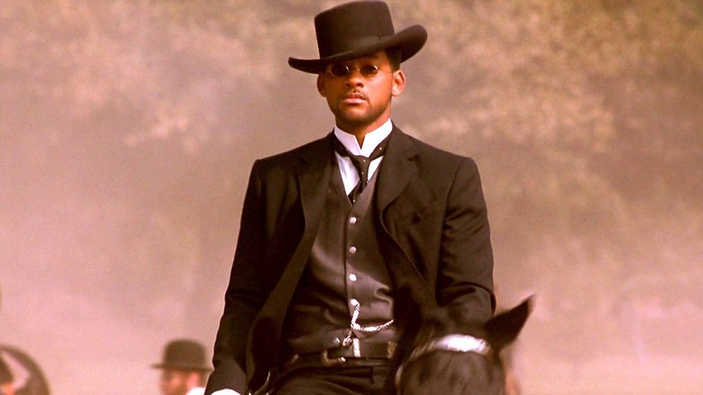 Jim West riding a horse and wearing sunglasses with a cowboy hat in Wild Wild West
