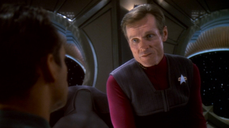 Luther Sloan leaning over talking to Dr. Bashir on Star Trek: Deep Space Nine