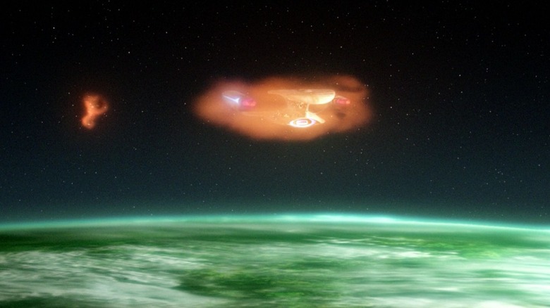The USS Enterprise-D entering the ionosphere of a planet with an enemy vessel behind it on Star Trek: The Next Generation