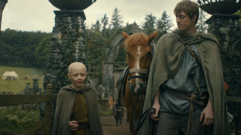 Peter Claffey as Ser Duncan the Tall and Dextor Sol Ansell as Egg walking together on a village path in A Knight of the Seven Kingdoms