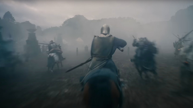 Peter Claffey as Ser Duncan the Tall on horseback charging through a smoky field against other knights in A Knight of the Seven Kingdoms