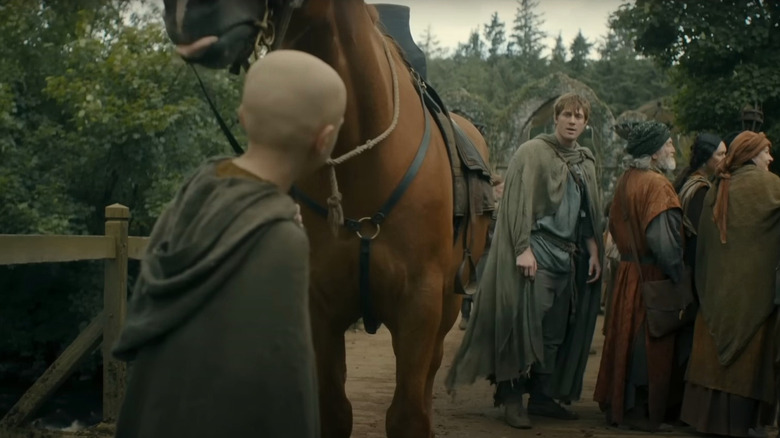 Peter Claffey as Ser Duncan the Tall and Dextor Sol Ansell as Egg talking among a crowd of villagers in A Knight of the Seven Kingdoms