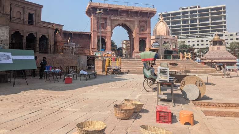 வாரணாசியின் பின்னணியில் கட்டப்பட்டு வரும் நவீன கால கட்டிடத்துடன் கூடிய முற்றத்தில் பழங்காலத் தோற்றமுடைய வளைவின் காட்சி