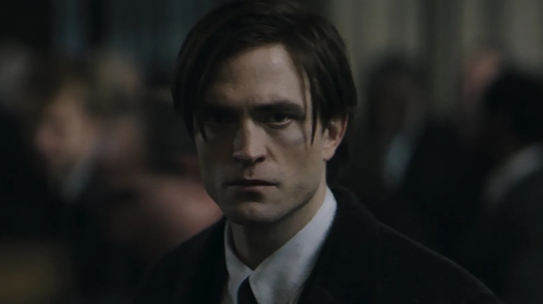 Bruce Wayne in a suit facing forward