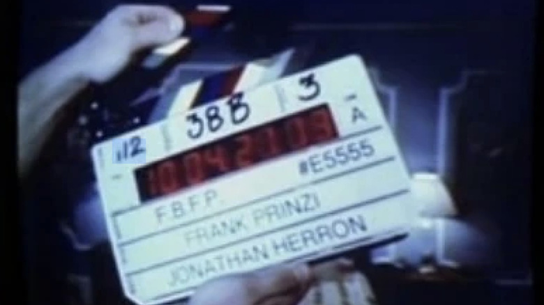 A hand holds up a film clapper on a blurry VHS tape in "Law & Order: Criminal Intent"