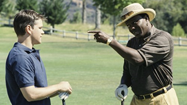 Bernie Mac, wearing a golf polo and hat, points a finger at Matt Damon, both holding golf clubs, in "The Bernie Mac Show"