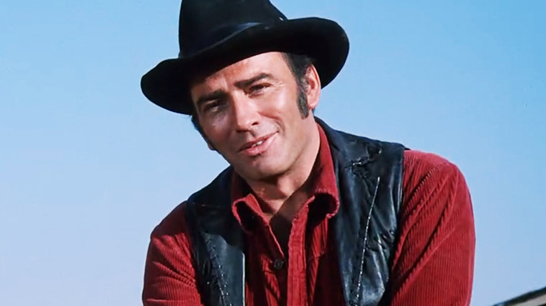 James Drury's Virginian stands against a clear sky in The Virginian