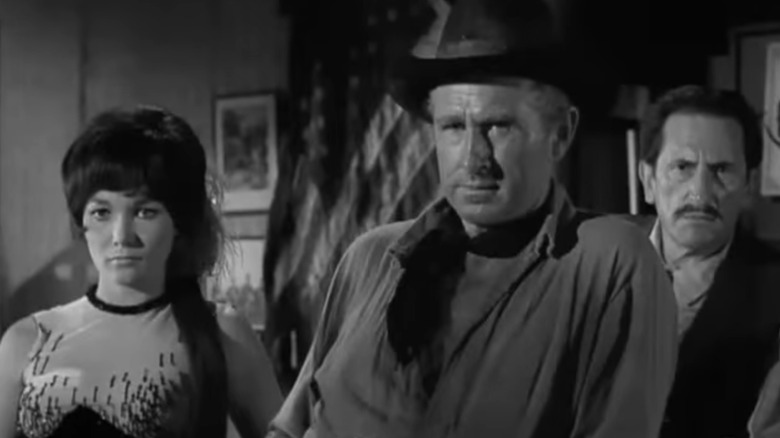 Lloyd Bridges' William Colton stands in a bar in The Loner