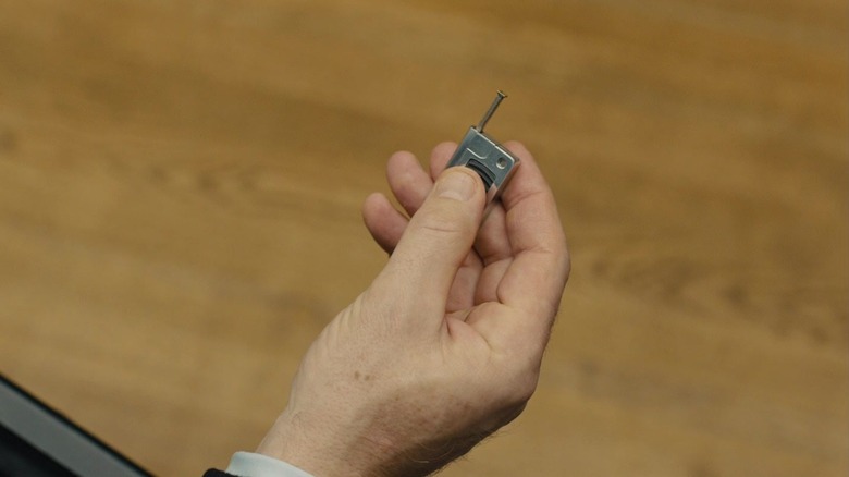Daniel Craig's James Bond's hand is seen holding a small radio transmitter in Skyfall