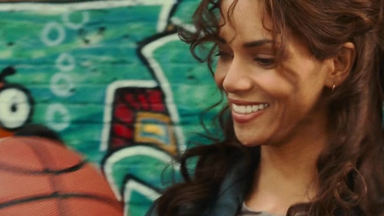 Halle Berry's Patience Phillips smiling at a basketball in Catwoman