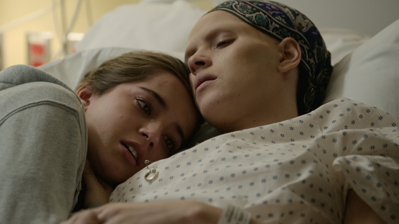 Isabela Merced's Rachel Cooper lays on the chest of Adria Arjona's Amanda Cooper in Sweet Girl