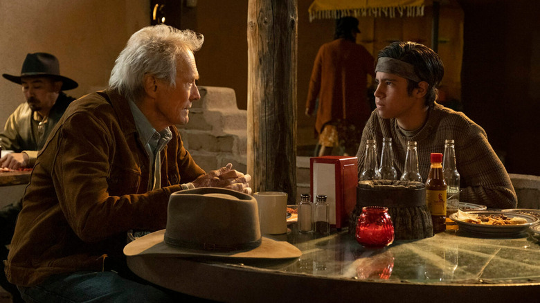 Mike Milo sitting at a diner table with Rafo in Cry Macho