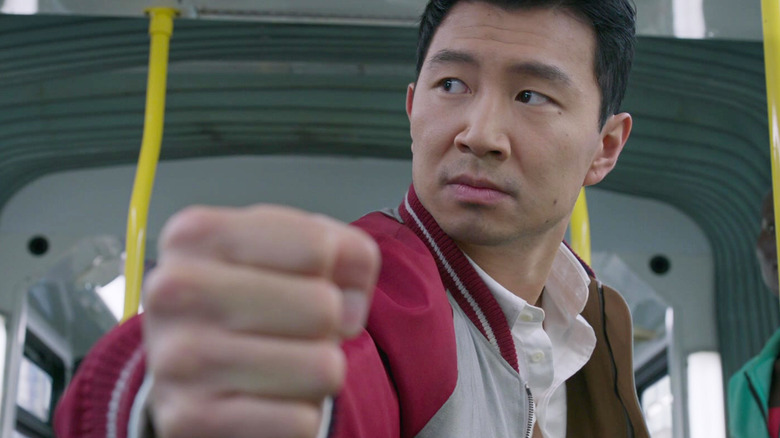 Simu Liu as Shang-Chi making a fist on a bus in Shang-Chi and the Legend of the Ten Rings