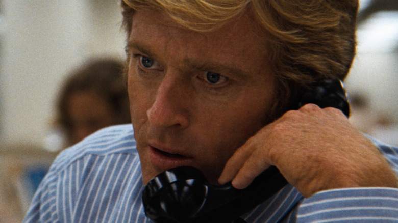 Bob Woodward staring intensely while on a phone call in All the President's Men