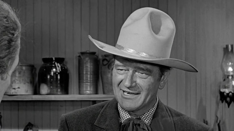 Tom Doniphon (John Wayne) in the middle of talking while wearing an oversized cowboy hat in The Man Who Shot Liberty Valance
