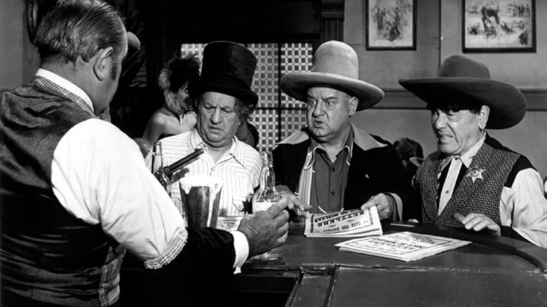 A bartender holds a gun on the Three Stooges in The Outlaws is Coming.