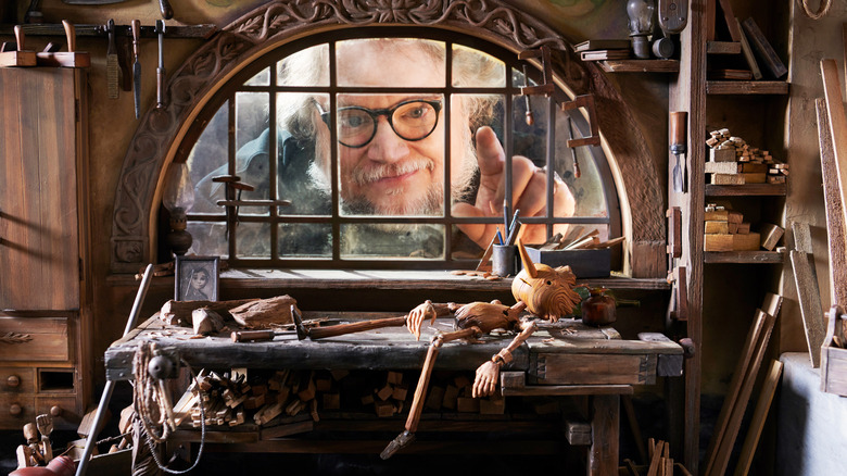 Guillermo del Toro pointing at Pinocchio in studio