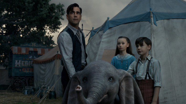 Holt Farrier and his kids looking at the horizon while petting a big-ear elephant in Dumbo