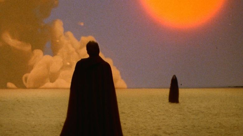 Two cloaked figures in a psychedelic desert in The Visitor