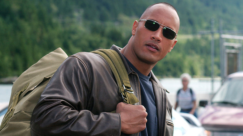 Dwayne Johnson as Chris Vaughn Jr. holding a cargo bag in Walking Tall