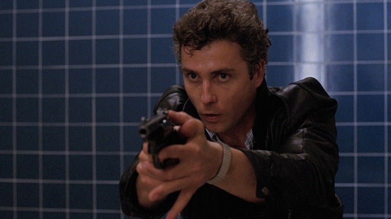 William Petersen aiming a revolver
