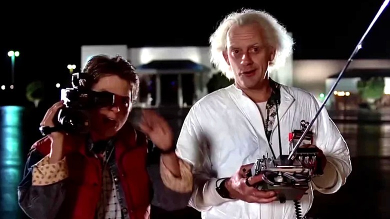 A shocked Marty McFly (Michael J. Fox) holds a camcorder while Doc Brown (Christopher Lloyd) holds a device in Back to the Future