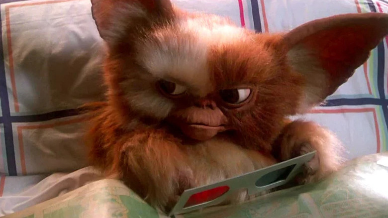 Gizmo (Howard Mandel) holds a pair of 3D glasses in Gremlins