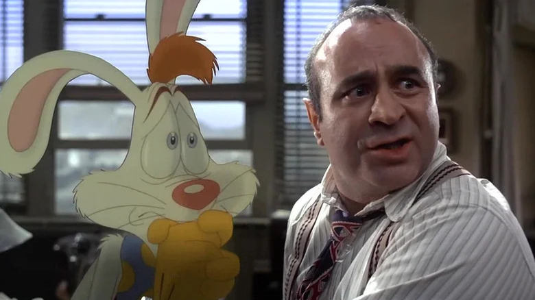 A worried Roger Rabbit (Charles Fleischer) and Eddie Valentine (Bob Hoskins) look at something in an office in Who Framed Roger Rabbit