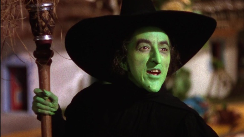 The Wicked Witch of the West holding her broomstick in The Wizard of Oz