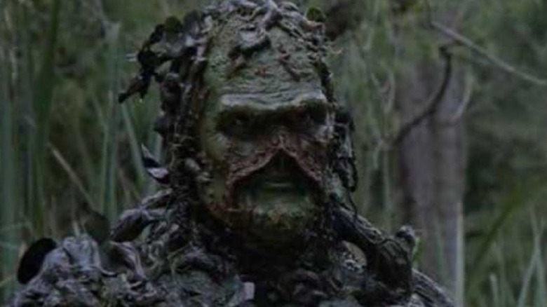 Swamp Thing staring sternly from behind branches