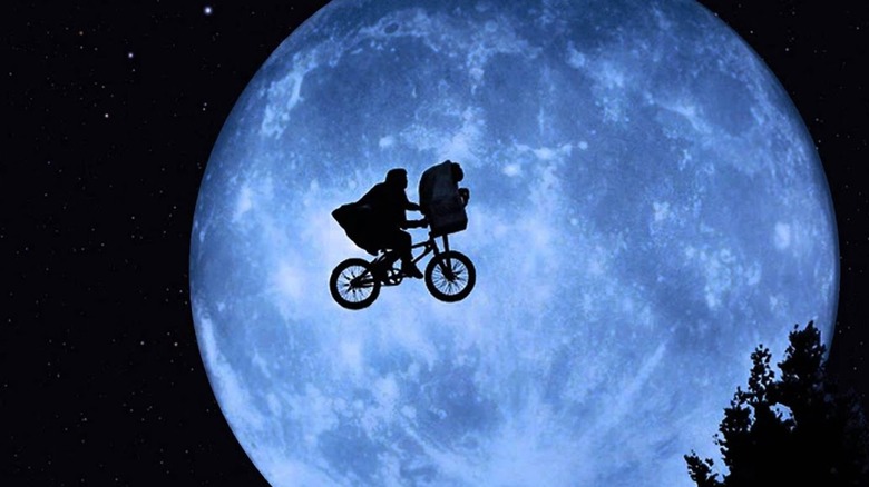 ET bike flying in front of moon