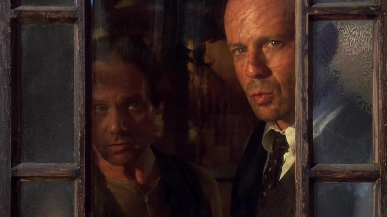 John Smith y Joe Monday están junto a una ventana abierta en la película Last Man Standing