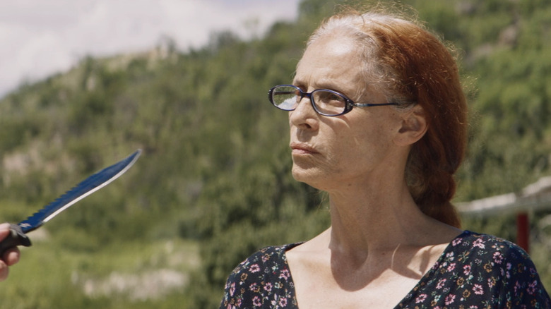 Sônia Braga as Domingas faces a knife held by someone standing off-screen in Bacurau