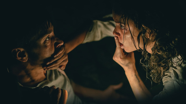 Georgina Campbell as Tess hushing Justin Long as AJ in Barbarian