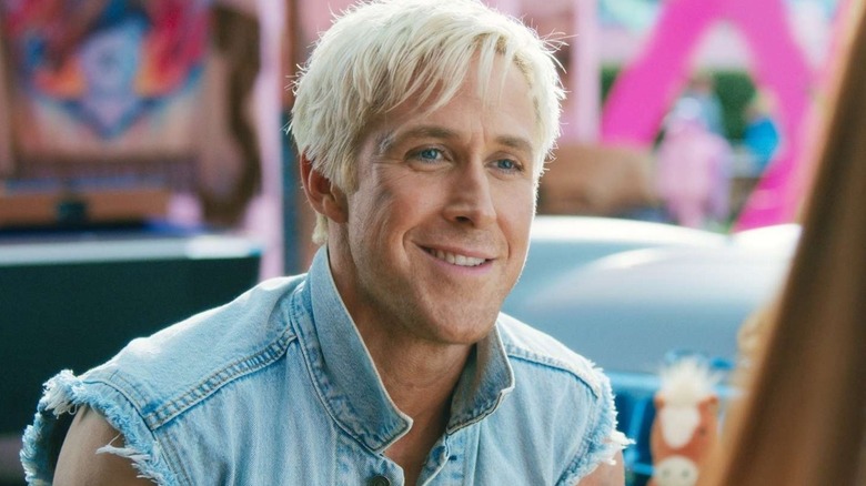 Ryan Gosling smiles a silly smile as he plays Barbie's Ken
