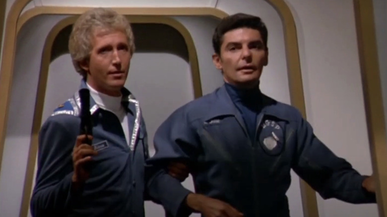 A blonde officer and Captain Quark in a hallway in the series Quark