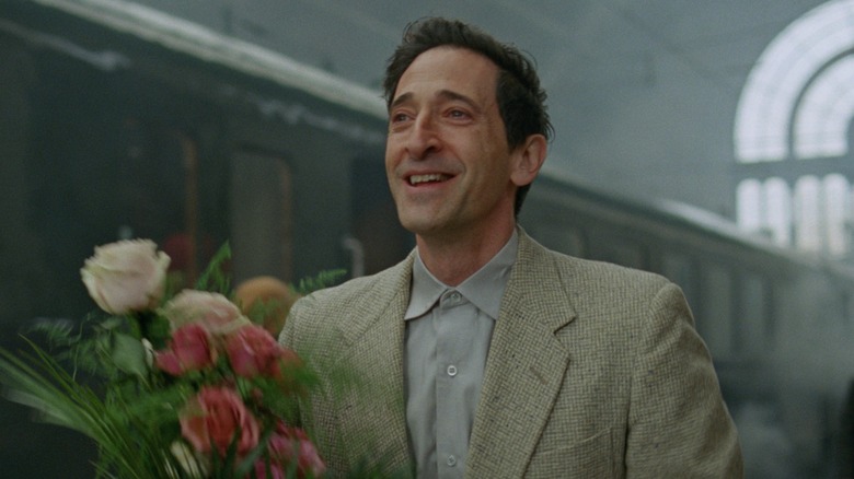 László Tóth carrying flowers in "The Brutalist"