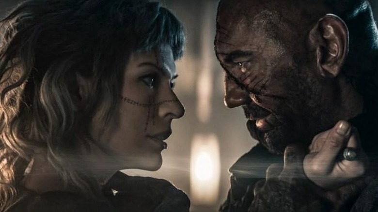 Gray Mila Djovavich holds a knife to Dave Bautists in the role of Boise from lost lands