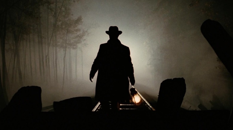 Brad Pitt's Jesse James stands on top of a train silhouetted in The Assassination of Jesse James by the Coward Robert Ford