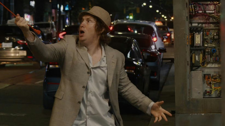 నిర్వణ్ణ ది బ్యాండ్ ది షో ది మూవీలో మాట్ జాన్సన్ ఆందోళనతో వీధిలో ఒక ఎక్స్‌టెన్షన్ కార్డ్‌ని లాగుతున్నాడు