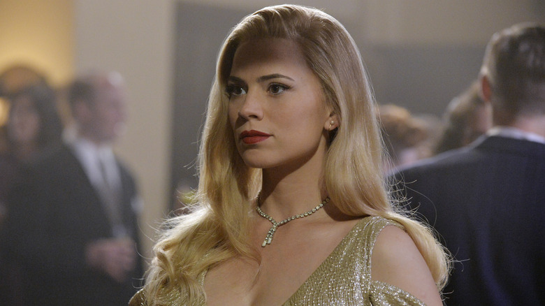 Agent Peggy Carter in disguise with blonde hair at a fancy event in Agent Carter