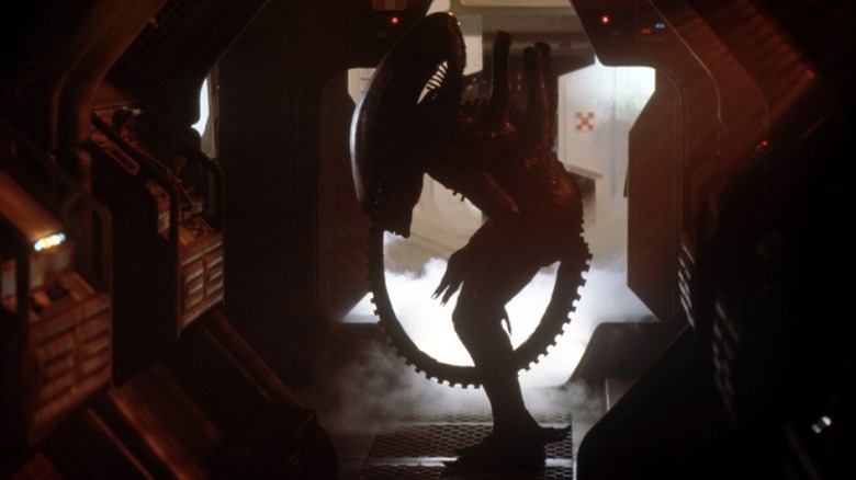 The extraterrestrial stranger, leaning in a spaceship corridor
