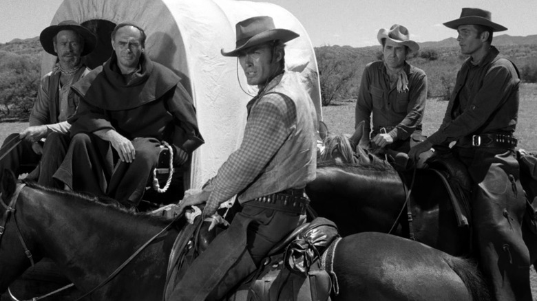 Clint Eastwood as Rowdy Yates sits on a horse surrounded by others in Rawhide
