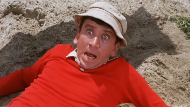 Bob Denver's Gilligan looks scared as he lays in sand in Gilligan's Island