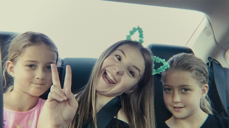 (L to R) Reese Rockstar Smith, Piper Rockelle, and Claire Rock Smith pose in the backseat of a car in Bad Influence